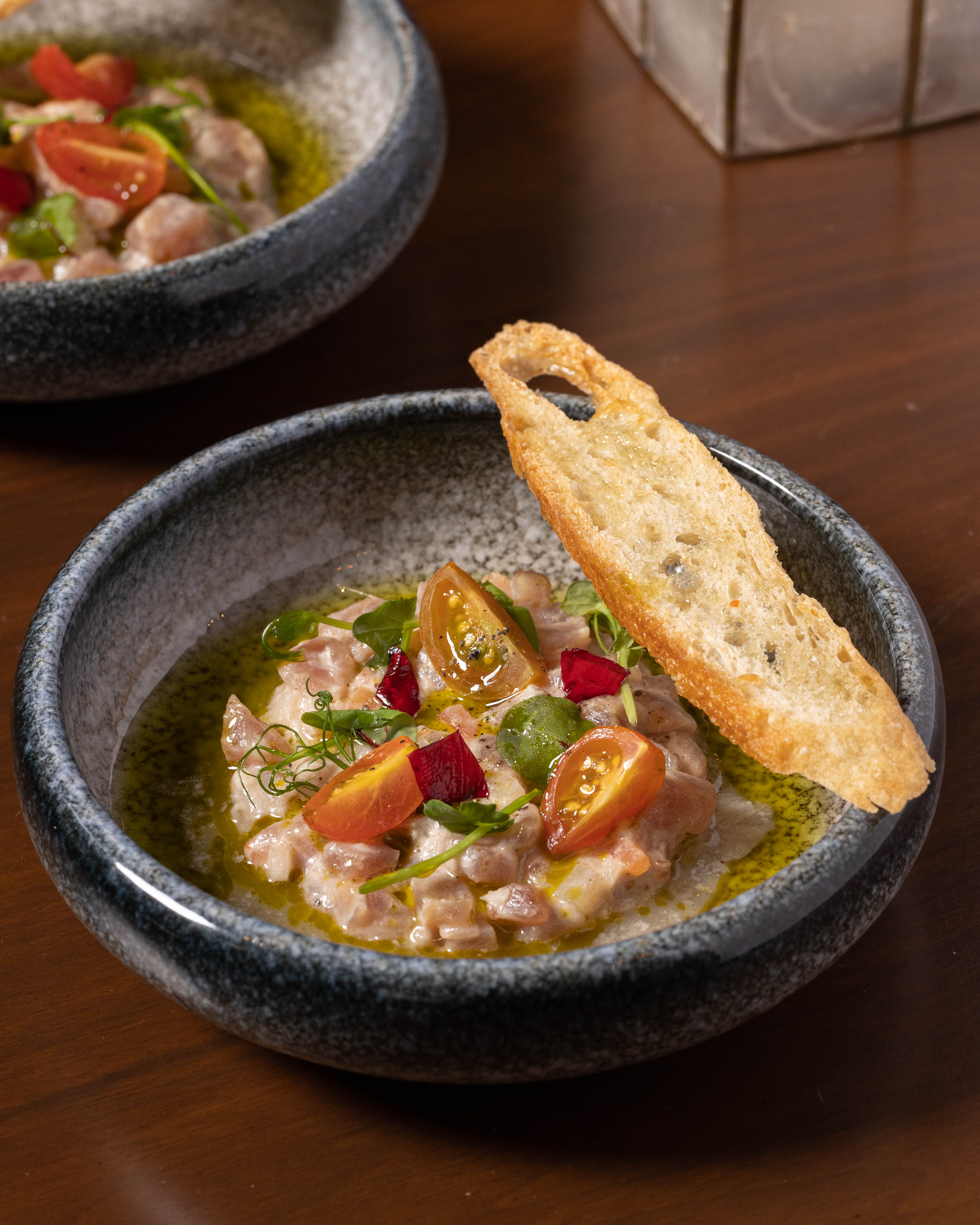 第二の料理、ハワク・カマイはマグロ、キュウリ、大根、酢を使ったキニラウ・ナ・イスダ（生魚の酢漬け）である。清らかで調和の取れたこの料理は、慣れ親しんだものから生まれる安らぎを映し出し、信頼が始まる瞬間を刻んでいる。